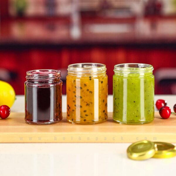 Straight-sided glass jars filled with assorted jams and preserves