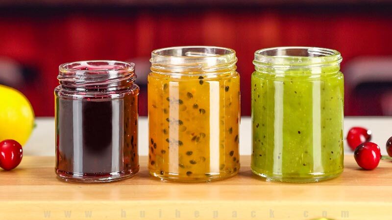 Straight-sided glass jars filled with assorted jams and preserves